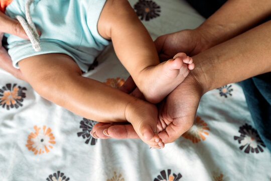 Parents gently holding baby feet showing love