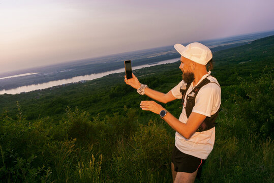 Runner Takes a Selfie With a Smartphone in Nature During Sunset