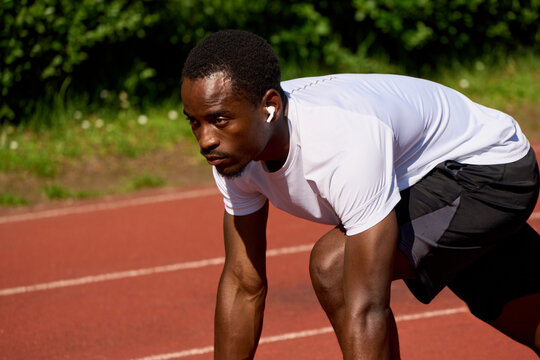Athlete Prepares for a Race on a Running Track in a Sports Field