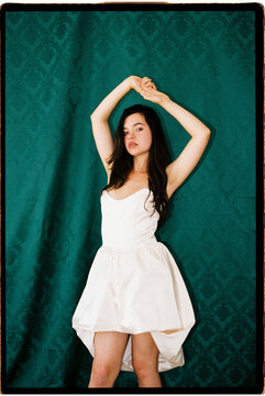 Woman posing against damask background