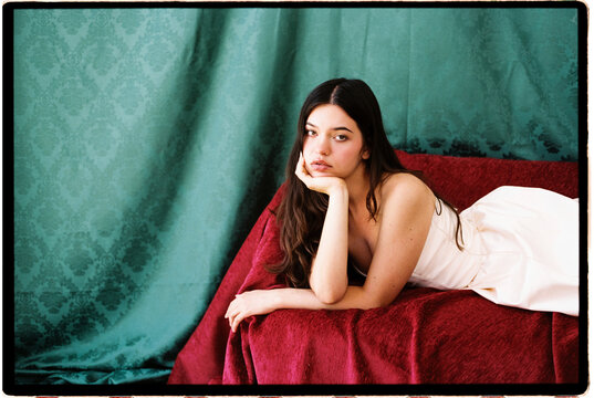 Woman posing on velvet sofa a