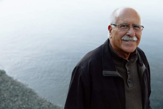 Candid portrait of a happy senior man by the water