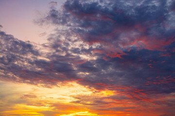 Fototapeta premium Stunning Vibrant Sunset Sky with Dramatic Colorful Clouds,A breathtaking and dramatic sunset sky filled with vibrant golden, orange, purple, and dark blue clouds, creating a peaceful and inspiring.