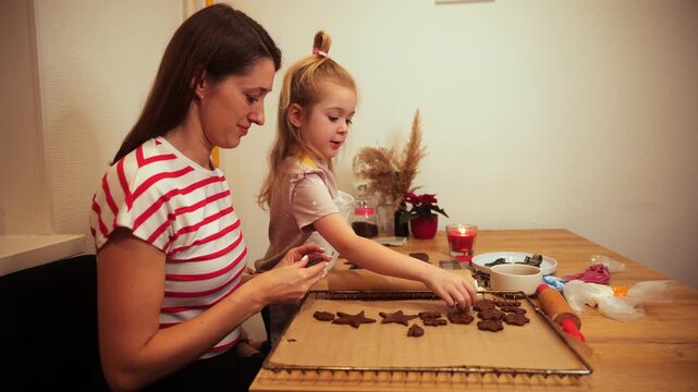 Mother and daughter make cookie shapes in cozy kitchen during afternoon
