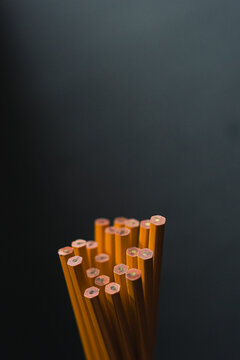 Yellow number two wooden pencils on dark blue gray background in natural light.