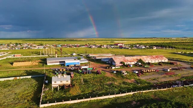Drone view of a farm with a rainbow in the sky.