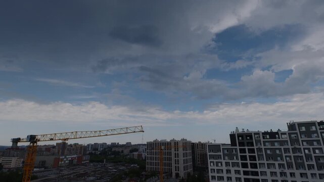 Timelapse of the clouds running fast over the buildings in a city
