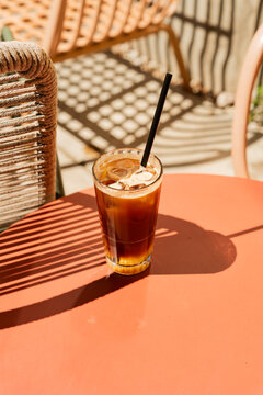 Vertical shot of iced espresso tonic glass on a terracotta table