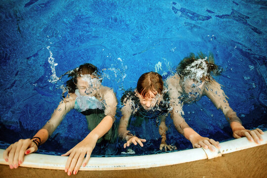 Kids Playing Underwater in a Swimming Pool on a Summer Day