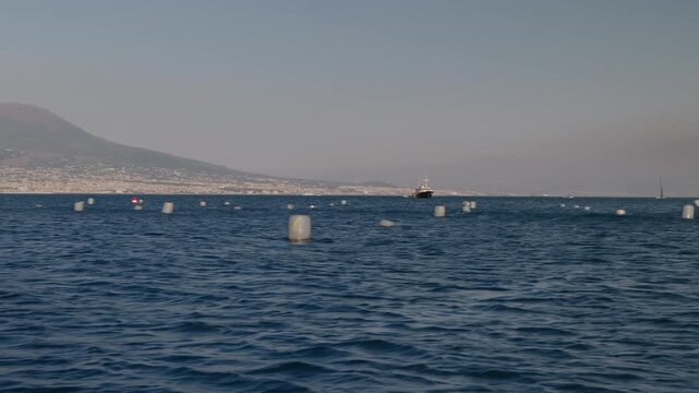 Floating buoys at a mussel farm in the Gulf of Naples, along the Mediterranean coast.