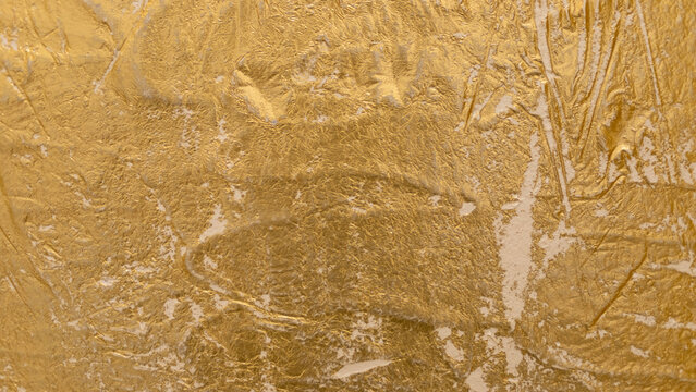 Textured golden stucco background with scratches, scuffs and stains. Plaster backdrop of golden yellow color for copy space.