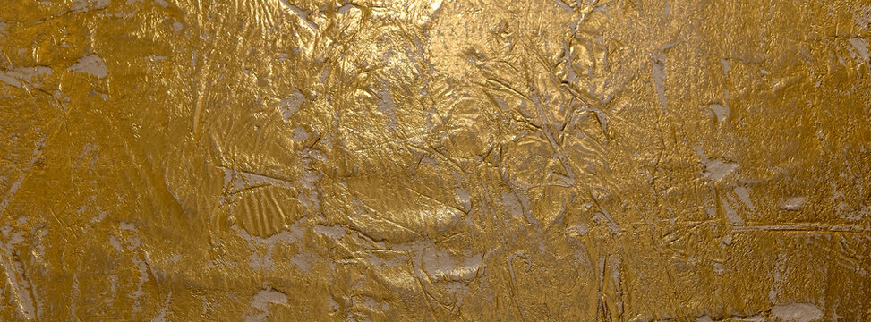 Close-up view of a golden textured Venetian plaster surface showcasing intricate patterns and shimmering highlights, ideal for backgrounds, design inspiration, or adding an elegant touch to visual pro