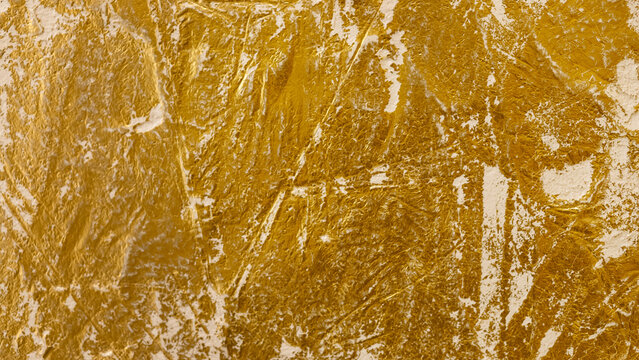 Textured golden stucco background with scratches, scuffs and stains. Plaster backdrop of golden yellow color for copy space.