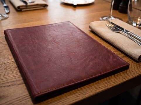 Burgundy Leather Restaurant Menu Cover on a Wooden Table Mockup