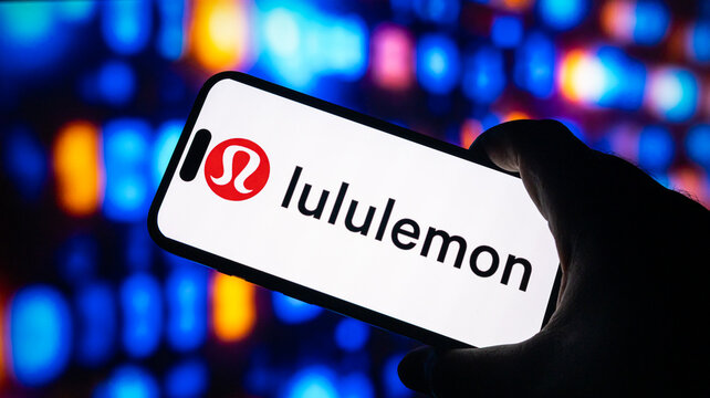 Lululemon logo shown on a smartphone screen held by a person, athletic apparel and wellness brand.