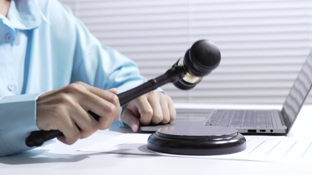 Legal court ruling with judge, gavel, laptop, office desk, and document work in courtroom business setting, focusing on law, justice, and professional office use