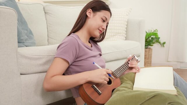 Young Asian Artist Writing Music in Cozy Living Room