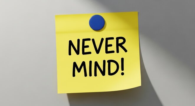 Yellow Sticky Note with Never Mind Text Pinned with Blue Magnet on Gray Surface, Concept of Changing Plans or Dismissal