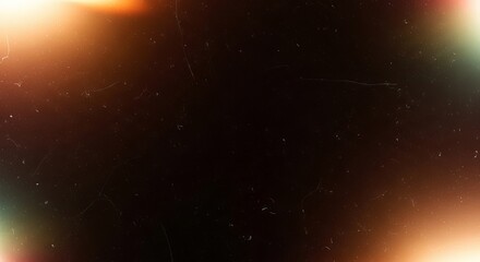 Fototapeta premium Vintage film texture overlay featuring glowing orange light leaks and dusty scratches on a dark black abstract photographic background surface
