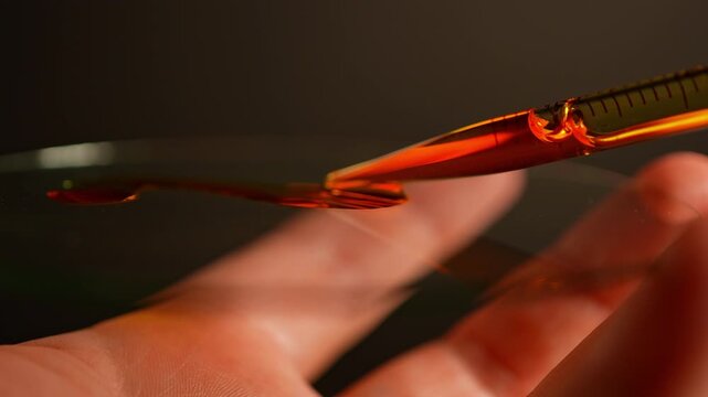 LSD in liquid dropped from pipette to glass surface, used in dance clubs and party. Lysergic acid diethylamide known as LSD and contain hallucinogens. LSD controlled substances and illegal.