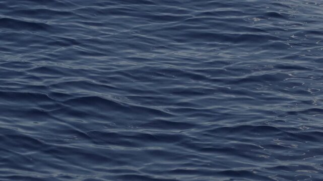 Sea surface with blinking stars and flares as seen from the moving sailing boat