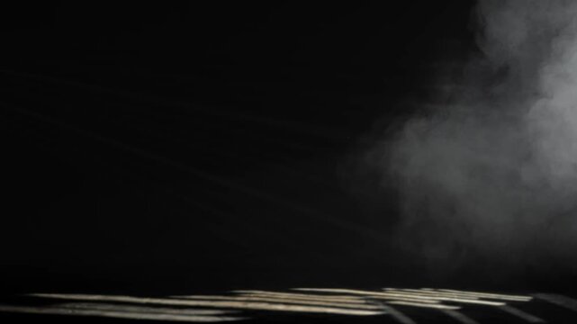 Gray smoke drifts above striped light shadows on a black stage. Concept event, theater, concert, cinema, mystery, advertising, backdrop, and visual design.