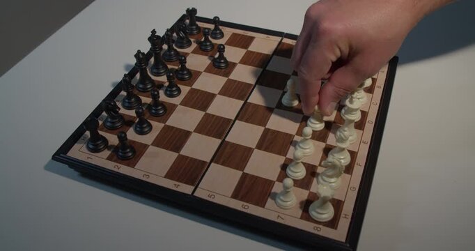 hand moving chess piece on board