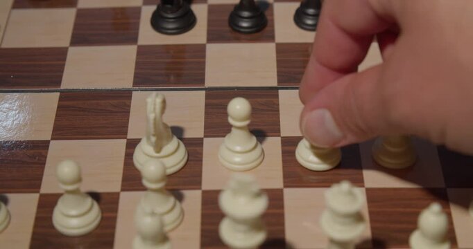 close up of hand moving chess piece on board