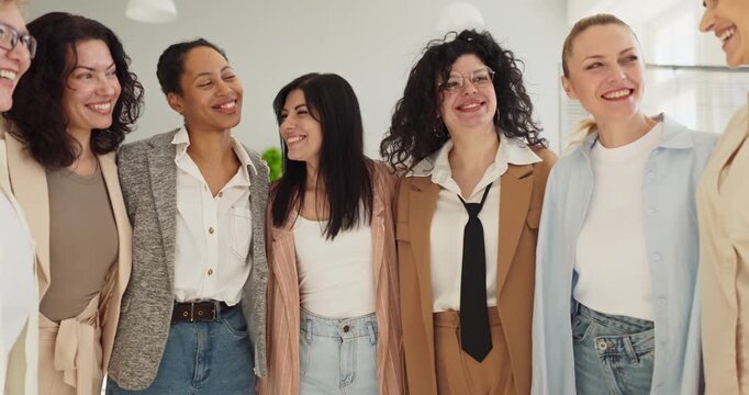 Women team group show teamwork and leadership. Smiling colleagues in a bright office celebrate collaboration. Unity and diversity build trust and shared success. Clear concept of unity at work.