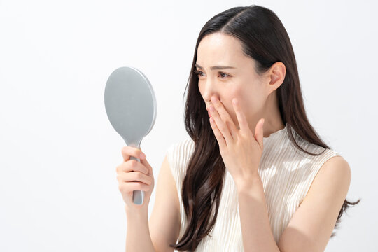 鏡を見て鼻を気にする女性