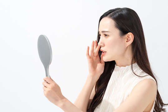 鏡を見て鼻を気にする女性