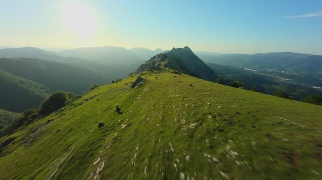 FPV Drone Flying Fast Over Lush Green Mountain Ridge Under Sunlight