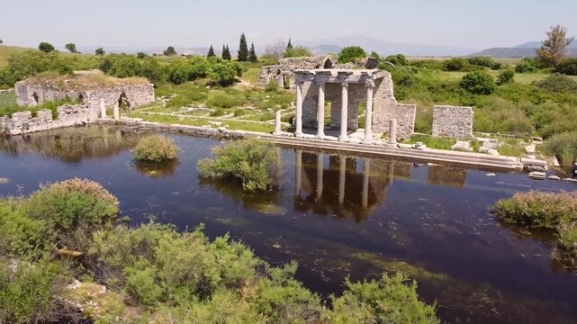 Scenic aerial flight around the flooded ruins of the ancient city of Miletus in Turkey. Historical landmark surrounded by green nature