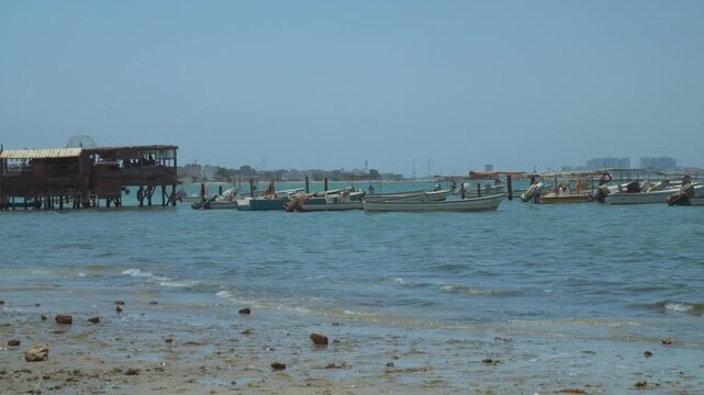 Fishing boats docked at a dirty beach on a windy day