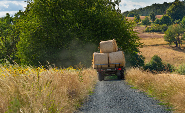 Abtransport der Strohballen auf Traktor auf Feldweg 