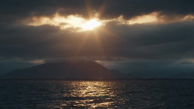 Remote view of the coastline as seen from the moving sailing vessel. Brazilian shore during sunset time as seen from a boat