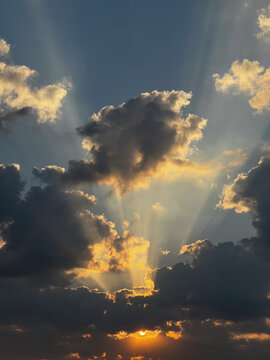Sunbeams piercing dark clouds at sundown
