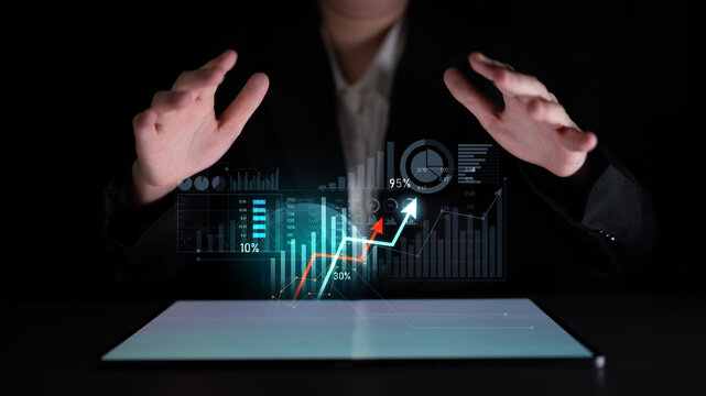 A business professional analyzes digital data represented by virtual graphs and charts on a tablet screen, emphasizing the importance of growth and success. Scalp