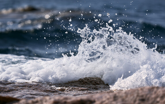 Dynamic Ocean Wave Crashing Against Rocky Shoreline with Sunlit Spray
