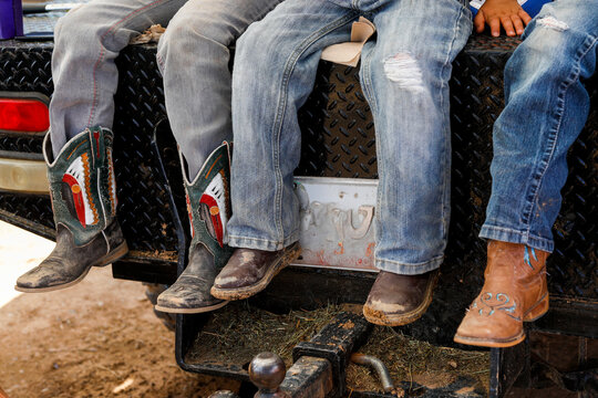 Young Boys with Cowboy Boots Sitting on Truck Tailgate