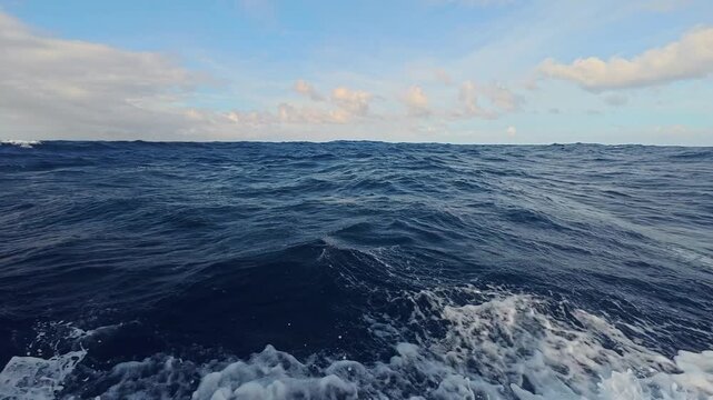 Ocean waves splashing against a moving boat in the open sea