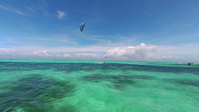 Kitesurfing in the turquoise tropical ocean water on a sunny day