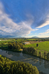 Fototapeta premium Aerial View Of Fraser Valley Farmland And River Near Chilliwack British Columbia Canada With Dramatic Sky