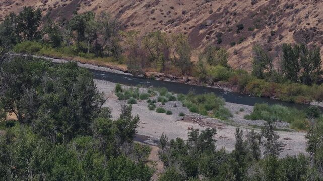 Aerial of naches river flowing in dry hillsides and riparian forest in Yakima Washington