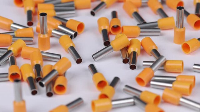 Metal tips with a plastic base for mounting on stranded copper wires. Close-up. Soft focus. Macro.