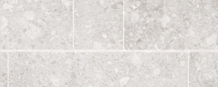 Light grey stone tiles surface for architectural flooring design featuring square slab patterns with natural granite mineral finish and clean white grout line spacing.