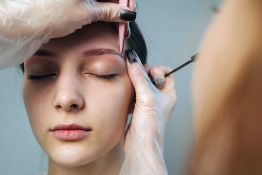 Woman getting eyebrow shaping in a beauty salon during a daytime appointment