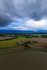 Obraz premium Aerial View of Fraser Valley Farmland and River With Storm Clouds Over Chilliwack, British Columbia, Canada