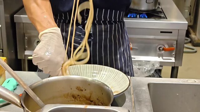 Chef handling ramen tsukemen noodles inside a bowl, Japanese Restaurant Kitchen, Cooking Fast Food Cuisine, Meal Preparation