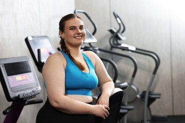 Fototapeta premium Portrait of happy overweight woman in gym